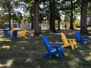 Free to use gold and blue lawn chairs decorating the inviting green space on TCNJ's campus.